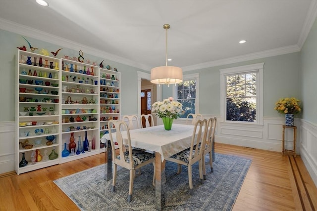 dining space featuring light wood-type flooring and crown molding