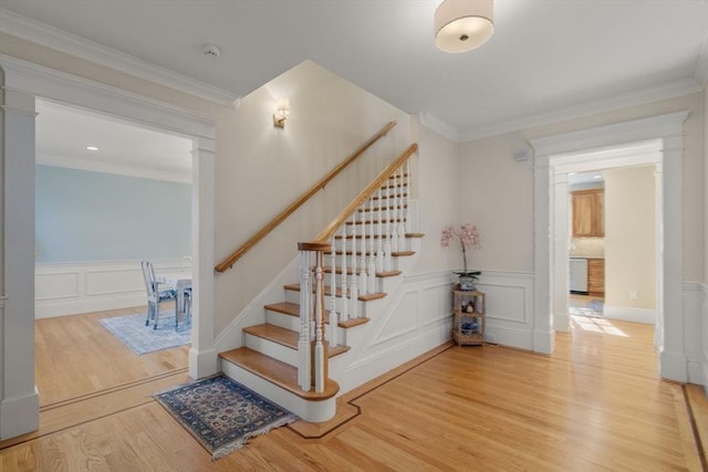 staircase featuring hardwood / wood-style flooring and ornamental molding