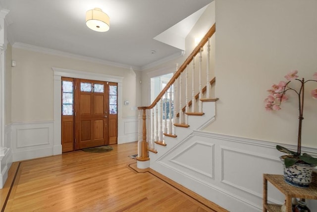 foyer entrance featuring ornamental molding and wood-type flooring