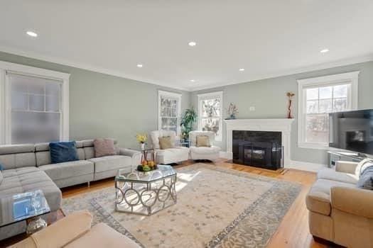 living room with crown molding and light hardwood / wood-style flooring