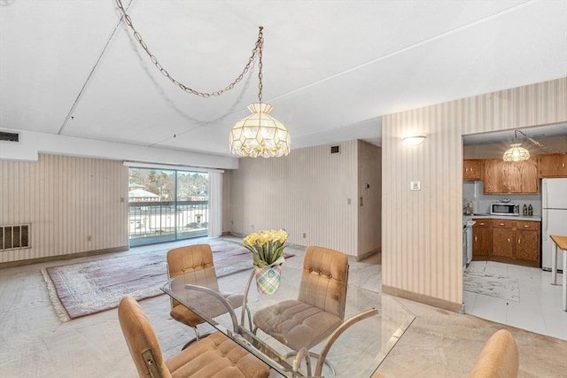 dining space with an inviting chandelier, baseboards, and visible vents