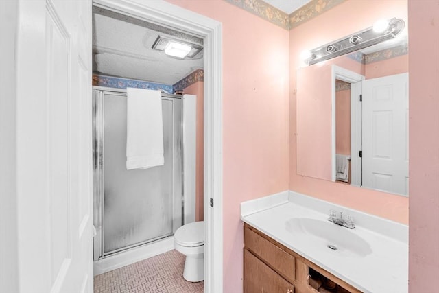 bathroom featuring a stall shower, toilet, and vanity