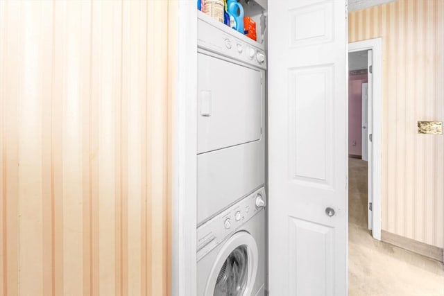 washroom with stacked washer and clothes dryer and laundry area