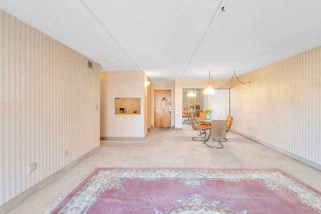 unfurnished dining area with visible vents, wallpapered walls, and baseboards