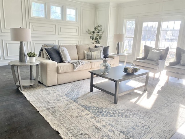 living room with dark wood-type flooring and a decorative wall