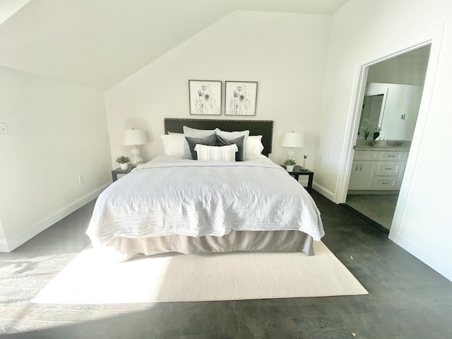 bedroom featuring vaulted ceiling, connected bathroom, and baseboards