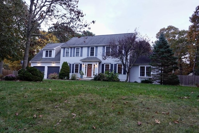 colonial inspired home with fence and a front yard