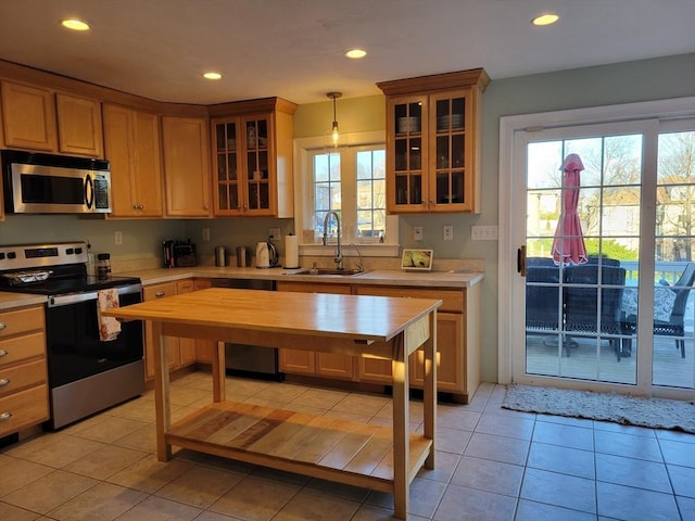 kitchen with sink, light tile patterned flooring, pendant lighting, and appliances with stainless steel finishes