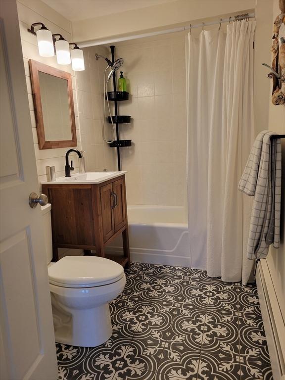 full bathroom with shower / bath combo, toilet, tile patterned flooring, and vanity