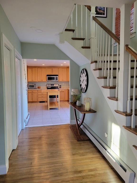 interior space featuring light brown cabinets, baseboard heating, light wood-type flooring, and stainless steel appliances