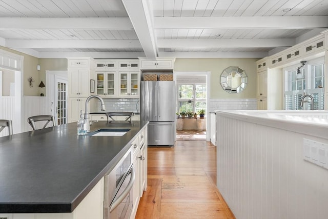 21 N Rd, Harwich, MA 02671 - kitchen with dark countertops, a sink, light wood-type flooring, stainless steel appliances, and a center island with sink