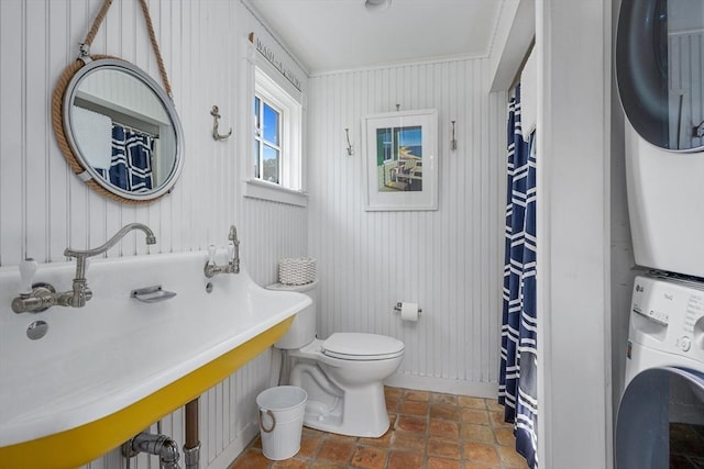 21 N Rd, Harwich, MA 02671 - bathroom featuring toilet, a shower with curtain, stacked washer and clothes dryer, and baseboards