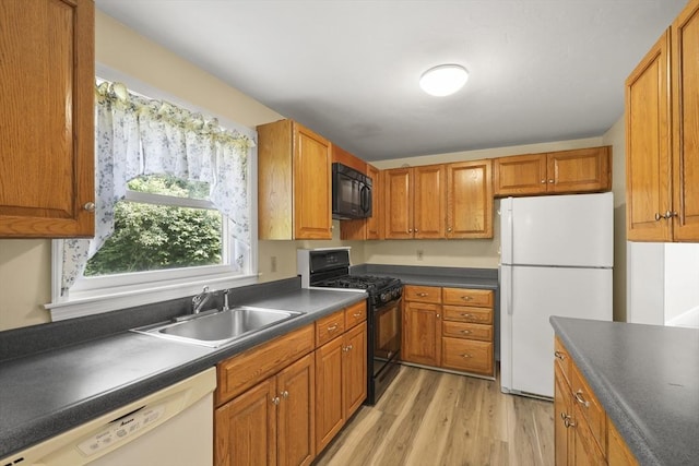 18 Harbor Hill Dr Unit 18, Bourne, MA 02532 - kitchen with black appliances, dark countertops, light wood finished floors, and brown cabinets