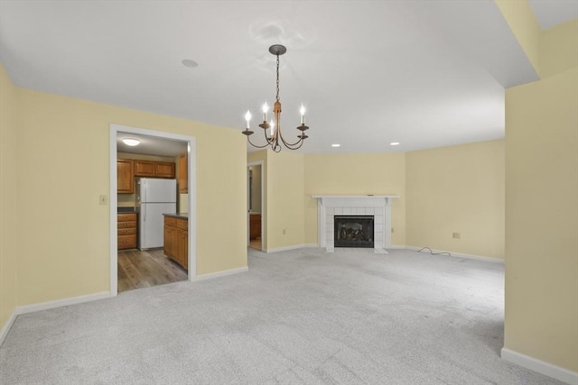 18 Harbor Hill Dr Unit 18, Bourne, MA 02532 - unfurnished living room featuring light colored carpet, a chandelier, and a tile fireplace