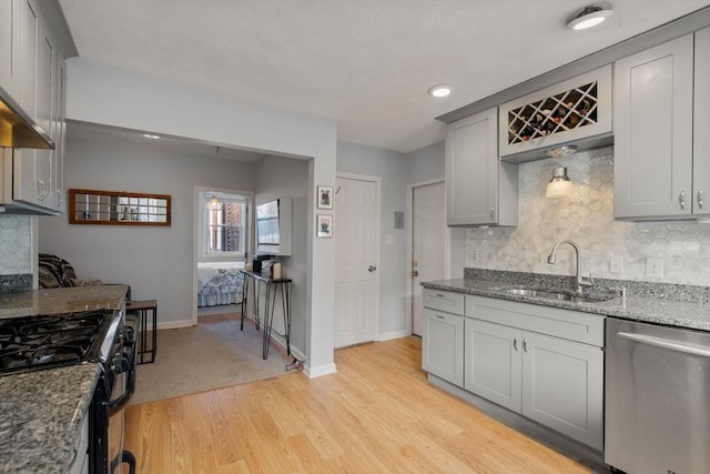 kitchen with sink, light hardwood / wood-style flooring, dishwasher, and tasteful backsplash