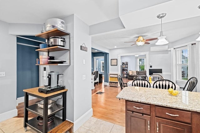26 N Munroe Ter Unit 1, Boston, MA 02122 - kitchen with ceiling fan, baseboards, a wall mounted AC, and light stone countertops