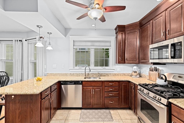 26 N Munroe Ter Unit 1, Boston, MA 02122 - kitchen with stainless steel appliances, a sink, a peninsula, ceiling fan, and light stone counters