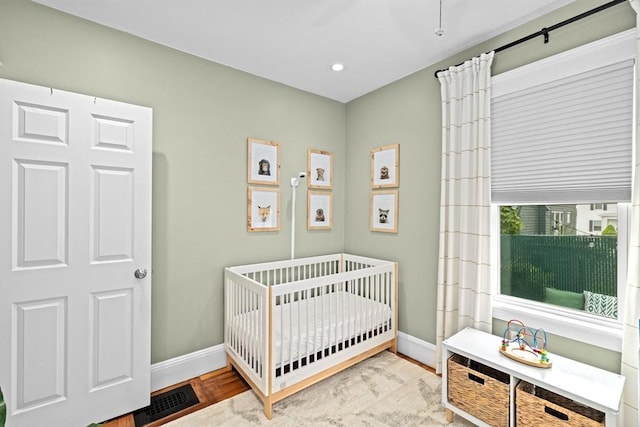 26 N Munroe Ter Unit 1, Boston, MA 02122 - bedroom with a nursery area, baseboards, wood finished floors, and recessed lighting