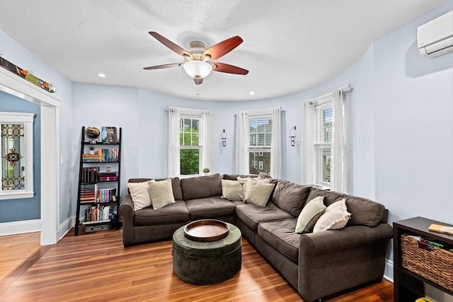 26 N Munroe Ter Unit 1, Boston, MA 02122 - living room featuring wood finished floors, a ceiling fan, a wall unit AC, baseboards, and recessed lighting