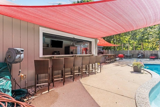 view of patio with a fenced in pool and a bar