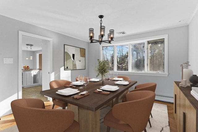 dining area featuring a chandelier, ornamental molding, and a baseboard heating unit