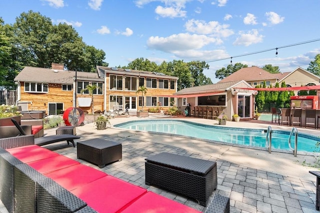 view of swimming pool with an outdoor hangout area, a bar, and a patio