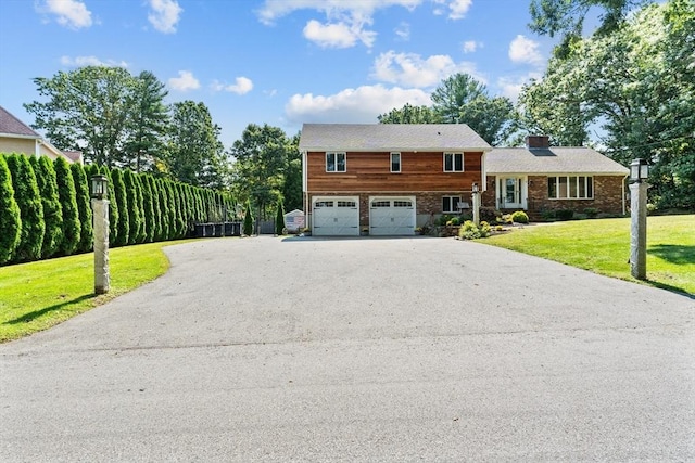 tri-level home with a front lawn and a garage