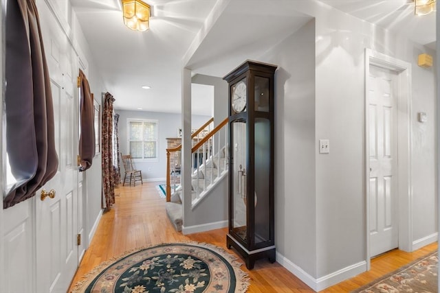 entrance foyer featuring stairs, light wood-style flooring, and baseboards