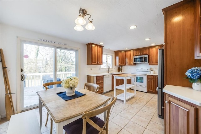 kitchen featuring stainless steel appliances, light tile patterned flooring, sink, and decorative backsplash