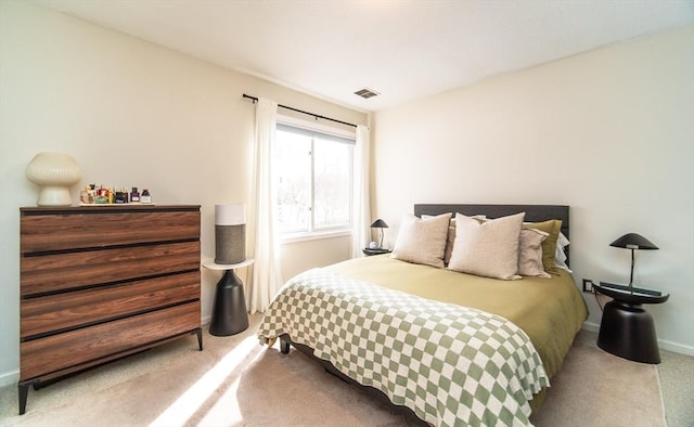 bedroom with light carpet, visible vents, and baseboards