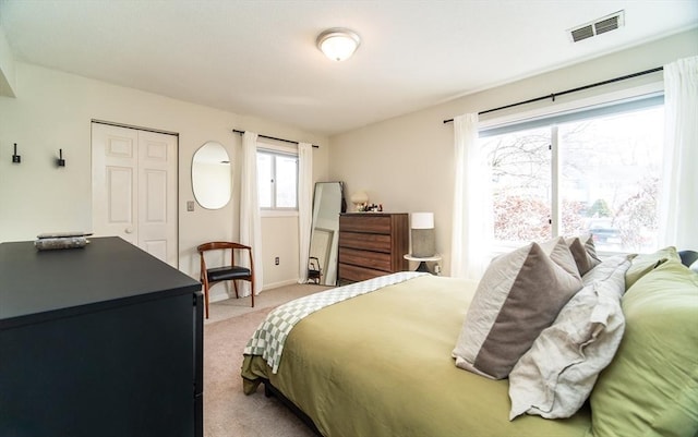 bedroom featuring light carpet, a closet, visible vents, and baseboards