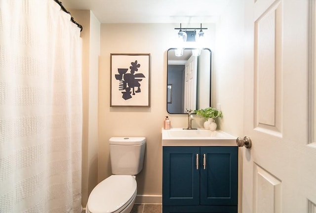 bathroom with baseboards, vanity, and toilet