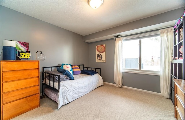 bedroom with a textured ceiling, carpet floors, visible vents, and baseboards