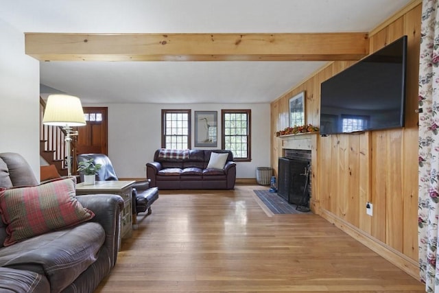 62 Teakettle Ln, Duxbury, MA 02332 - living area featuring light wood-style floors, a fireplace with flush hearth, beamed ceiling, stairs, and wood walls