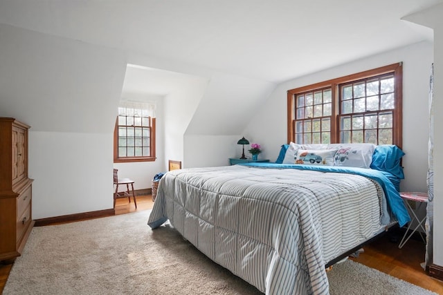 bedroom with carpet flooring and lofted ceiling