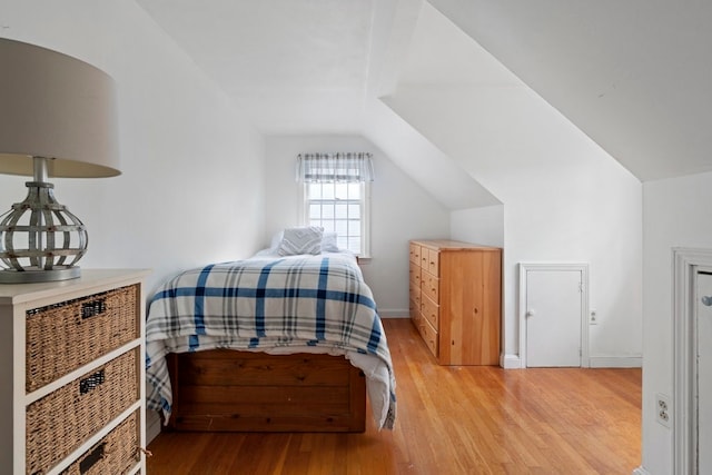 bedroom featuring light wood-type flooring and vaulted ceiling