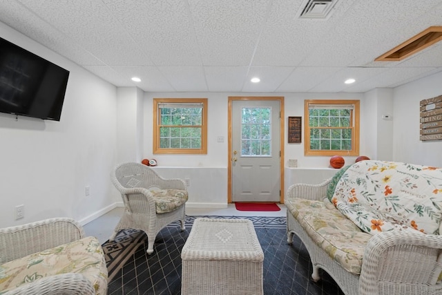 living room with a paneled ceiling and plenty of natural light