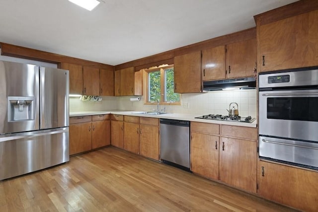 62 Teakettle Ln, Duxbury, MA 02332 - kitchen with stainless steel appliances, a warming drawer, under cabinet range hood, light countertops, and tasteful backsplash