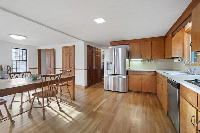 62 Teakettle Ln, Duxbury, MA 02332 - kitchen with stainless steel appliances, light wood-style flooring, light countertops, and brown cabinetry