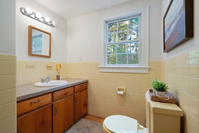 bathroom featuring vanity, toilet, and tile walls