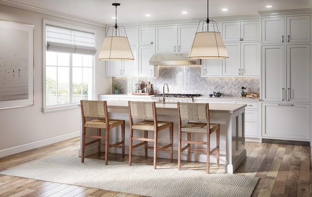 kitchen featuring pendant lighting, a center island with sink, and light hardwood / wood-style floors