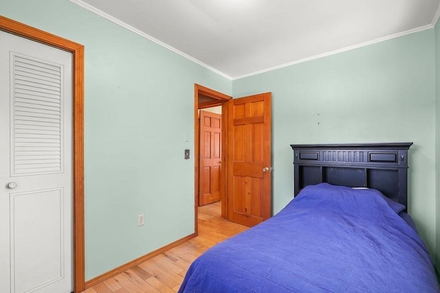 bedroom with baseboards, ornamental molding, and wood finished floors