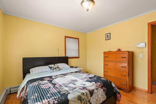 bedroom featuring baseboards, light wood finished floors, a baseboard radiator, and crown molding