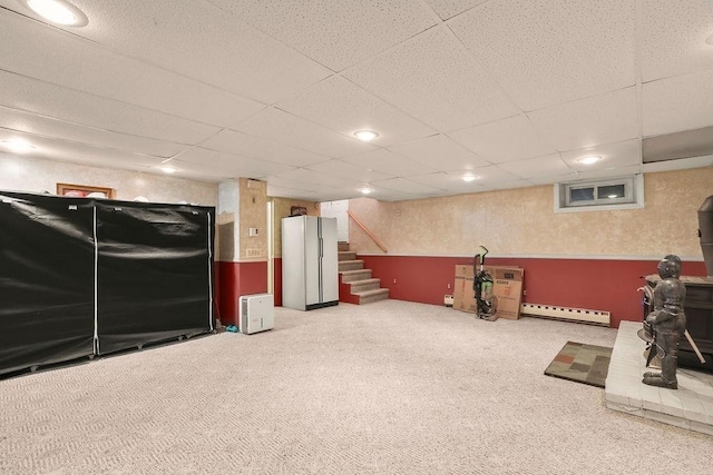 interior space featuring a paneled ceiling, stairway, carpet flooring, and freestanding refrigerator