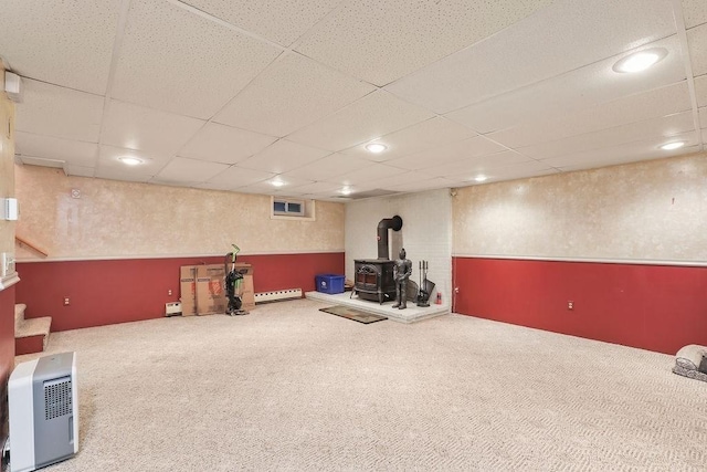 exercise area with a wood stove, carpet, a drop ceiling, and recessed lighting