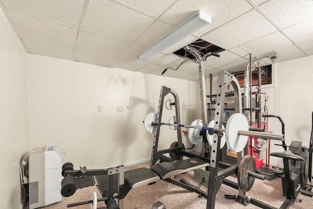 workout room with carpet floors, a drop ceiling, and baseboards