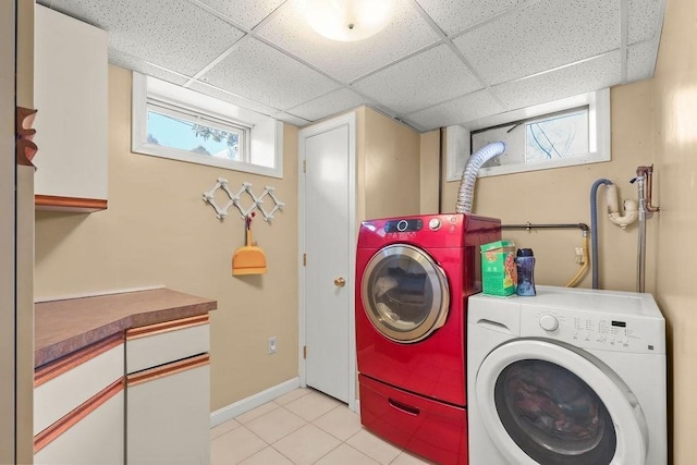 washroom with cabinet space, baseboards, separate washer and dryer, and light tile patterned flooring