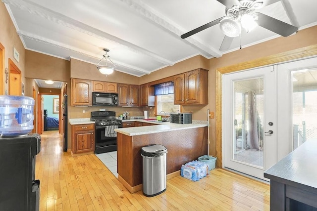 kitchen featuring vaulted ceiling with beams, light countertops, brown cabinetry, a peninsula, and black appliances