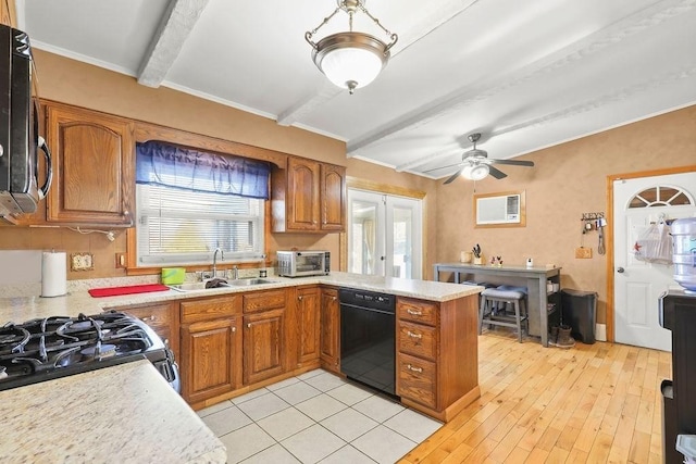 kitchen with brown cabinetry, black dishwasher, stainless steel microwave, and light countertops