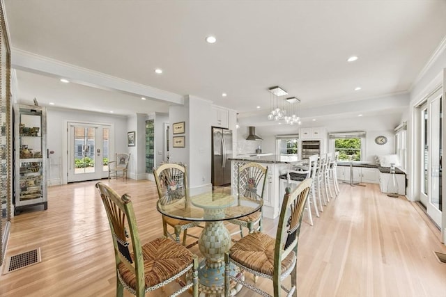 dining room with light wood-type flooring, crown molding, recessed lighting, baseboards, and a chandelier